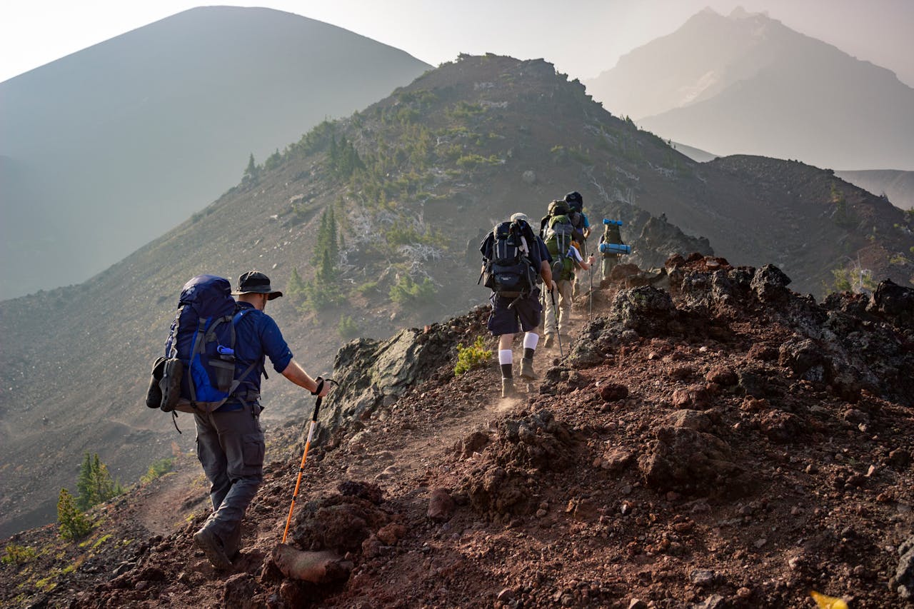 services-03 Group of hikers trekking on a rugged mountain trail in Oregon's scenic outdoors.